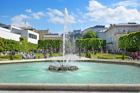 Salzburg, Austria - May 23, 2018 : people relax by the fountain in the Mirabell park in Salzburg, old historic Fortress Hohensalzburg in the backgroundのeditorial素材
