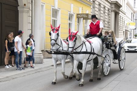 VIENNA, AUSTRIA - 26 may 2019: people have a horse ride in the traditional old-fashioned fiacre, walk through magnificent Viennaのeditorial素材