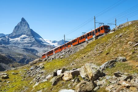 ZERMATT, SWITZERLAND - September 03, 2019: red train on the background of Matterhorn peak in the Swiss Alps (Pennine Alps)のeditorial素材