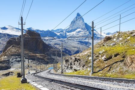 magnificent landscape in the Swiss Alps, in the foreground a railway, in the background a mountain Matterhornの写真素材
