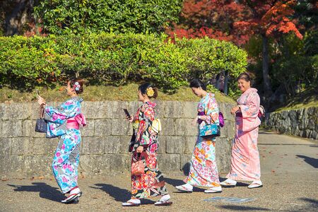 Kyoto, Japan-November 12, 2019: young girls in traditional japanese clothing (kimono) walk in Kyoto parkのeditorial素材