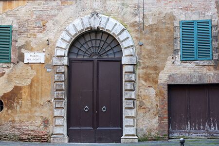 old iron gate in a medieval house, Piazza del Conte, Siena, Italyの写真素材