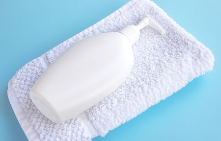 Body milk lie on a white towel, on a blueの写真素材