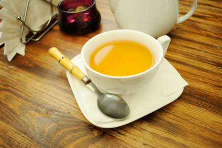 Break for tea in cafe. A cup of green tea, sugar bowl, spoon, teapot and decoration on the table. の写真素材