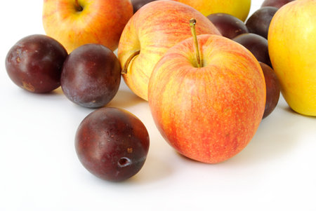 Colorful apples and plums on white backgroundの写真素材