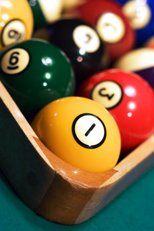 Close up of Racked pool balls with the tight focus on a 1-ball. Picture was taken in low light, to...