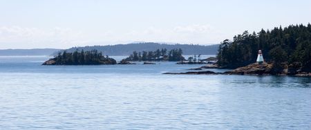 Lighthouse on the rocky wooded island. Gulf Islands. British Columbia.の写真素材
