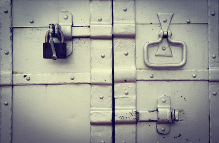 Steel lock on the rusty grey metal doorの写真素材