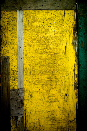 Wall painted in yellow, cracked. Abstract backgroundの写真素材