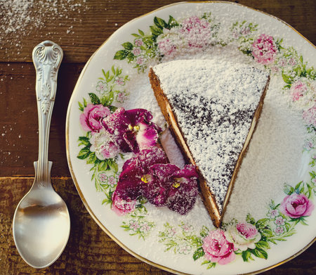 Homemade chocolate cake with cream cheese, walnuts and flowers, sprinkled with sugar powder