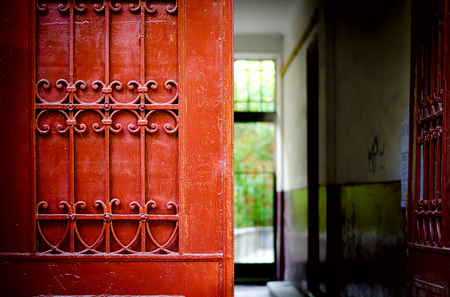 Red door detail with wrought iron ornaments.の写真素材