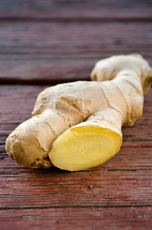 Ripe ginger root sliced on wooden tableの写真素材