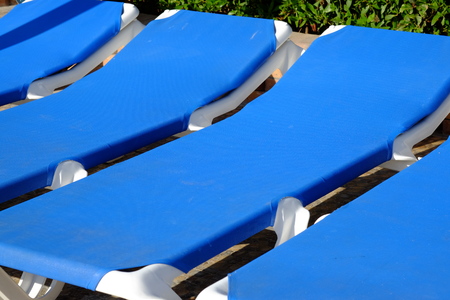 Blue beach chairs and sun umbrella near pool. Travel background.の写真素材