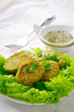 Vegetarian patties of broccoli with salad, pepper, greens and herbs, on white backgroundの写真素材