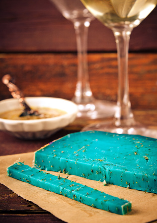 Blue pesto cheese with herbs, pomegranate jam and sauces on wooden rustic background.の写真素材