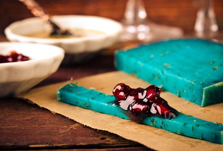 Blue pesto cheese with herbs, pomegranate jam and sauces on wooden rustic background.の写真素材