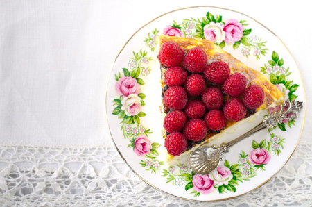Cheesecake, souffle, cream mousse, pudding dessert with fresh raspberries and mint leaves on a white...