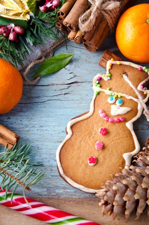 Christmas, New Year Composition with Gingerbread Man, Tangerines, Fir Tree, Pine cones, Cinnamon and Candy Canes. Shiny Holiday Decoration on Blue Wooden Backgroundの写真素材