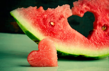 Fresh juicy watermelon heart at turquoise wooden background. Saint Valentine, love greeting card, toned, horizontalの写真素材