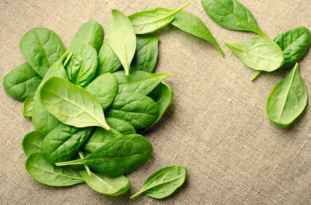 Fresh Baby spinach leaves on sackcloth background. Top view with copy space. Healthy, Ecology conceptの写真素材