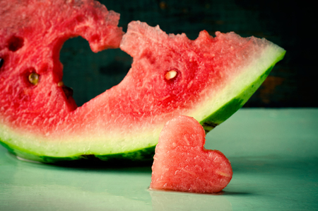 Fresh juicy watermelon heart at turquoise wooden background. Saint Valentine, love greeting cardの写真素材