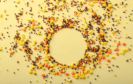 Circle frame made of sugar candies, pastry decoration on yellow background.の写真素材
