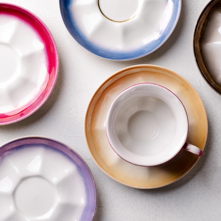 Empty colorful porcelain tableware, cups and plates on grey backgroundの写真素材