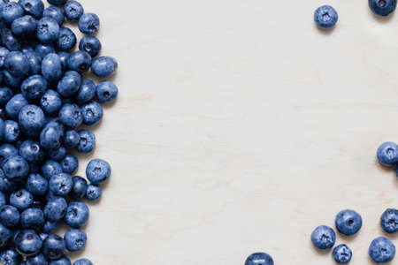 Scattered blueberries on a wooden background. Place for your text.の写真素材