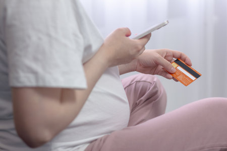 Pregnant girl makes online payment. The concept of online shopping, payment via the Internet. Close-up.の写真素材