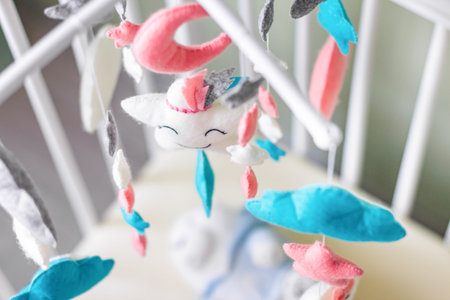 Toys above the baby crib. Baby crib mobile with stars, clouds and moon.