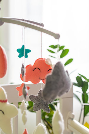 Baby crib mobile. Toys above the baby crib. Hanging soft clouds, stars and moon for the child. Verticalの写真素材