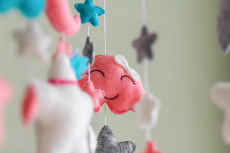 Baby crib mobile with stars, clouds and moon. Kids handmade toys above the newborn crib. First baby eco-friendly toys made from felt hanging in light room.の写真素材