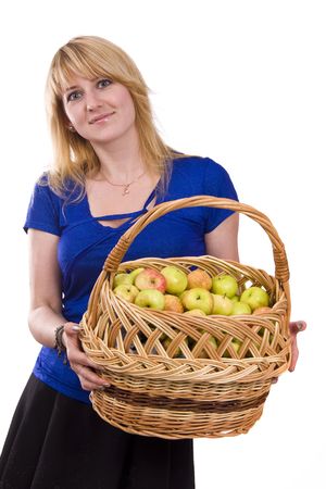 Woman in blue blouse standing and holding a basket full apples on white background. Beautiful girl holding a basket of delicious fresh fruits. Pretty girl with basket of apples. Isolated over white.の写真素材