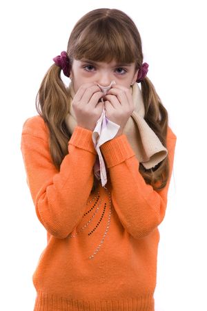 Sneezing. Little girl on white background in winter clothing is sick. Female have sore throat and sneezing.の写真素材