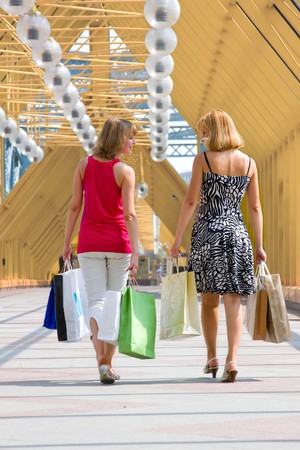 Beautiful young women shopping. Young woman holding several bags in shopping centre. Two friends on a shopping tour in the city の写真素材