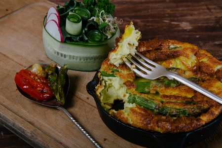 Frittata with asparagus on wooden tableの写真素材