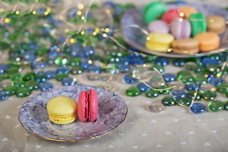 Colorfull and sweet macaroons on a table on a table with xmas lightsの写真素材