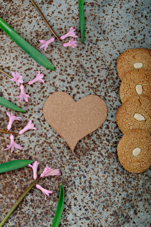 Rustic wooden background with cup of coffee and decorations. Heart shaped chalkboard. Spring flowers Top viewの写真素材