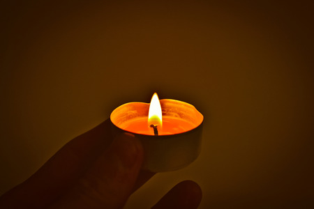 Hand holding a candleの写真素材