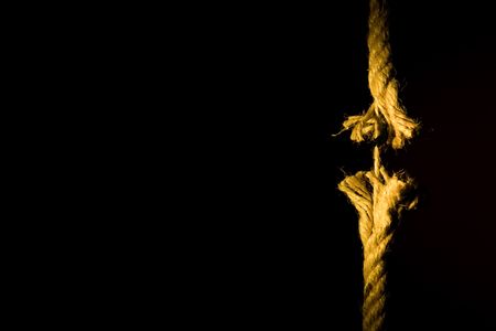 Frayed rope breaking on a dark backgroundの写真素材