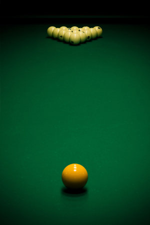 Yellow sphere on a billiard table in a night club