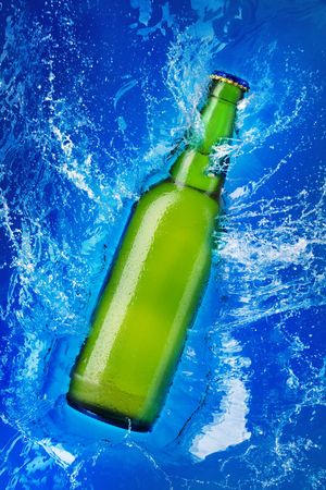 beer bottle being poured in a waterの写真素材