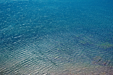Sea water surface with ripple and sun reflectionsの写真素材