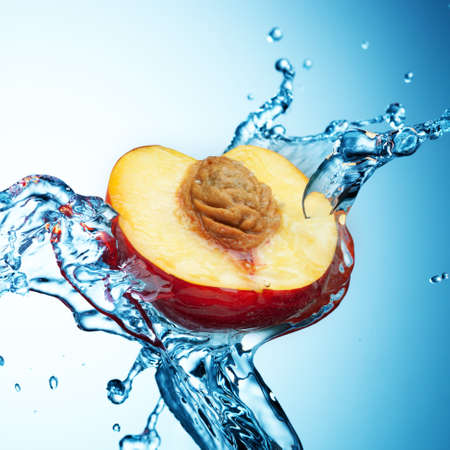 Peach in spray of water. Juicy peach with splash on backgroundの写真素材