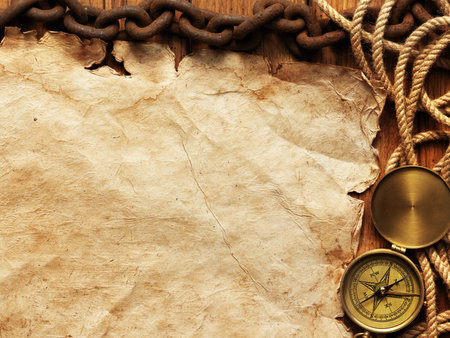 Compass, rope, paper, chain on wooden board