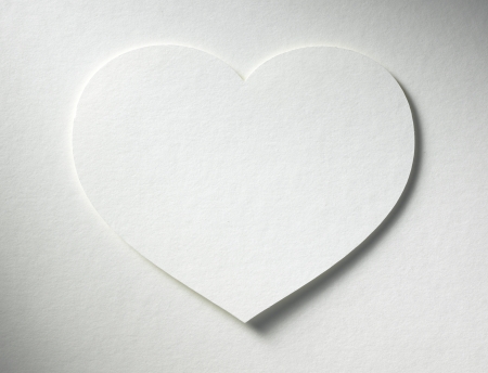 heart cutted from paper lies on the paper backgroundの写真素材