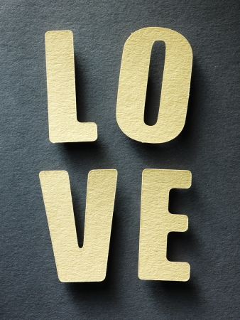 The word Love in cut out paper letters on paper backgroundの写真素材