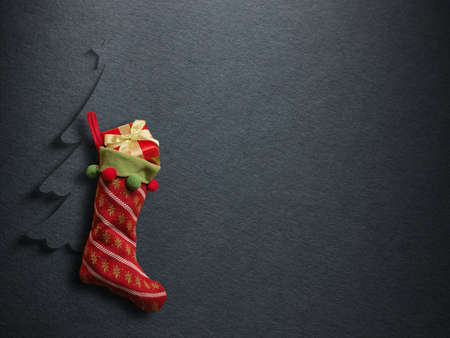 Christmas sock with red gift box on paper backgroundの写真素材