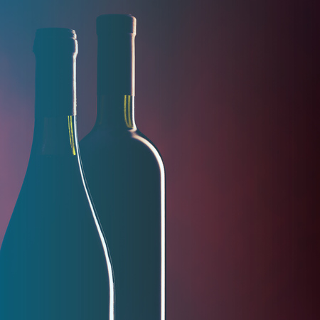 Bottles of red wine on dark red background. Filtered image: vintage effect.の写真素材