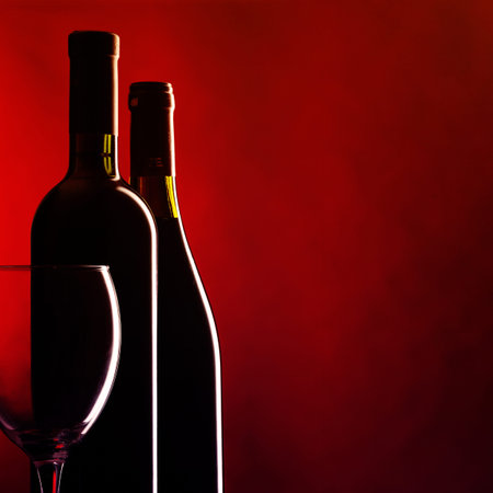 Bottle and glass of red wine on dark red background. Filtered image: vintage effect.の写真素材